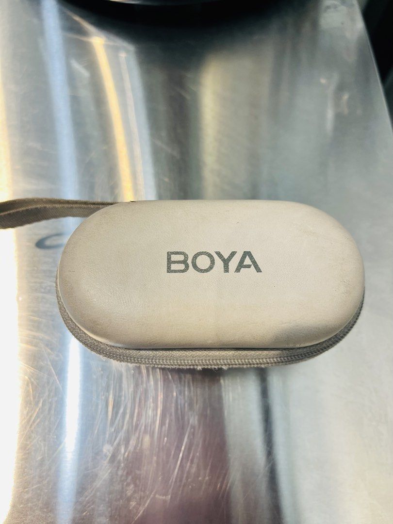 BOYA OMIC (Category: Microphones) located in Antipolo. Submitted by justfrancexoxo (Listing ID 1427985012, Image 1). Description: BOYA wireless microphone system with a carrying case. Includes two round transmitters, a receiver, and a charging adapter. The case has a zipper closure and a handle. The case has some signs of wear. Twice lang nagamit nailagay lang sa closet nalimutan kaya medyo nagbakbak na yung charging case and medyo na yellow na P