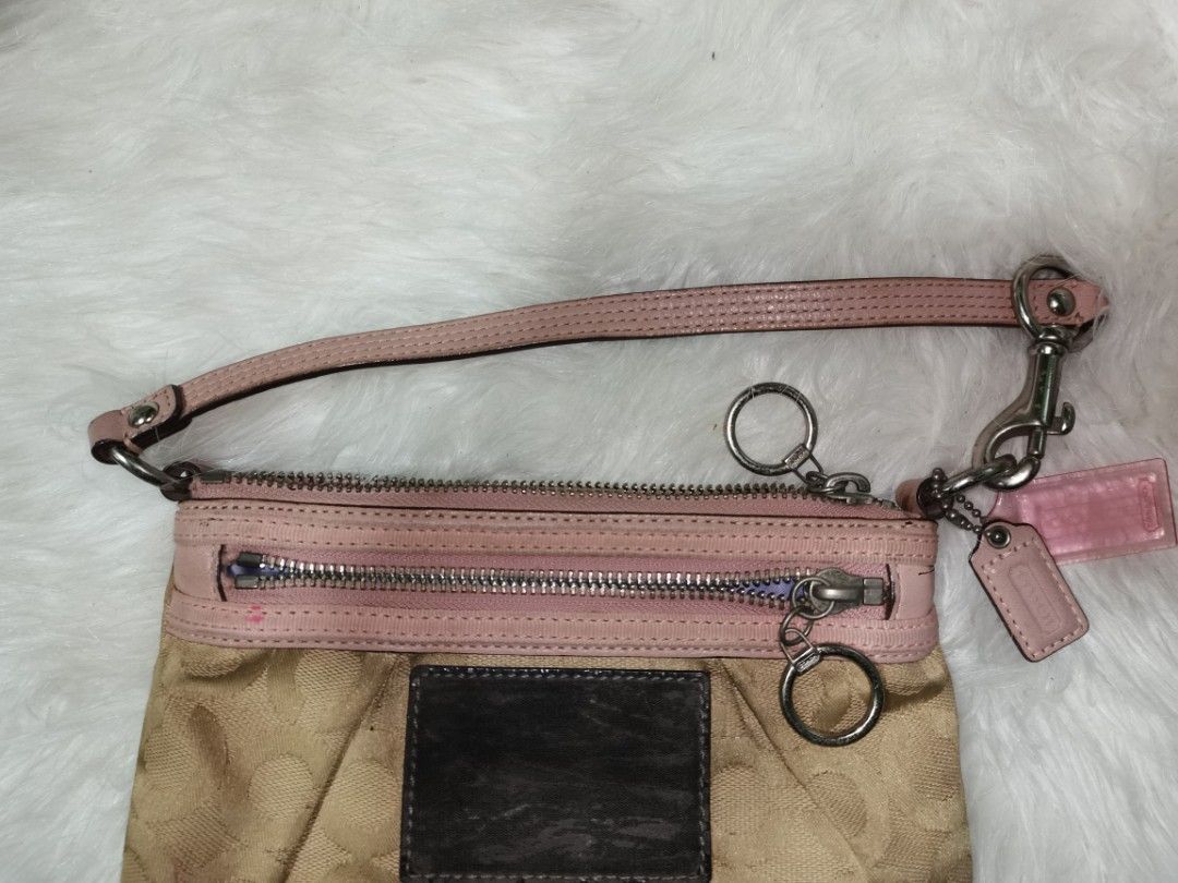 Coach Signature Pink Handbag (Category: Luxury Bags & Wallets) located in Manila. Submitted by eagerbeaverph (Listing ID 1428043226, Image 3). Description: Coach handbag features a signature pattern with pink accents. It has a zip closure and a detachable strap. The interior lining is light blue. The bag includes a small leather tag and a metal ring detail. Made in China. Coach poppy Shoulder bag wristlet y2k H 5 inches W 8.
