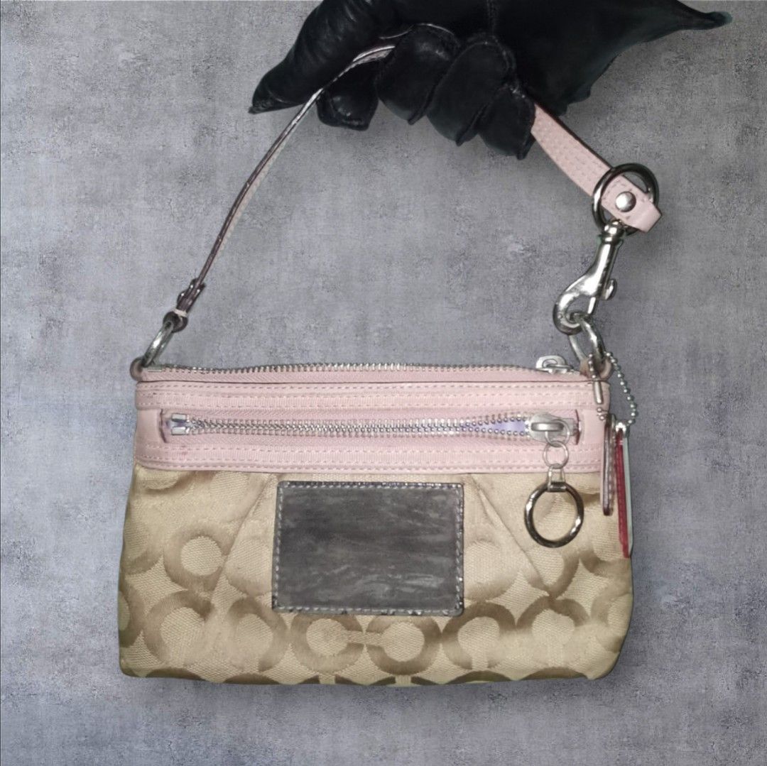 Coach Signature Pink Handbag (Category: Luxury Bags & Wallets) located in Manila. Submitted by eagerbeaverph (Listing ID 1428043226, Image 1). Description: Coach handbag features a signature pattern with pink accents. It has a zip closure and a detachable strap. The interior lining is light blue. The bag includes a small leather tag and a metal ring detail. Made in China. Coach poppy Shoulder bag wristlet y2k H 5 inches W 8.