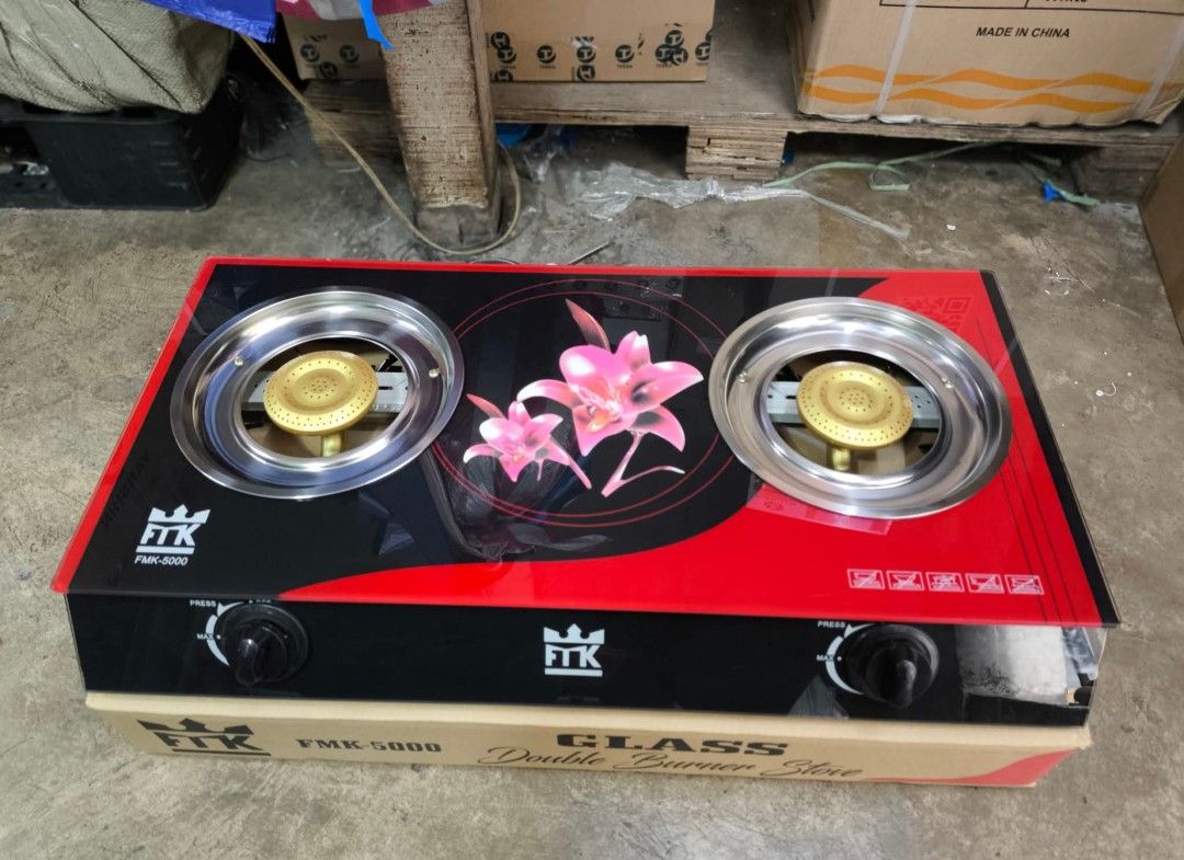 Double Burner Glass Gas Stove (Category: Other Kitchen Appliances) located in Manila. Submitted by yzlshop (Listing ID 1427953857, Image 1). Description: FTK FMR-5000 double burner gas stove features a sleek glass top with a floral design. It has two burners with individual control knobs. The stove is red and black in color. The item is still in its original box..