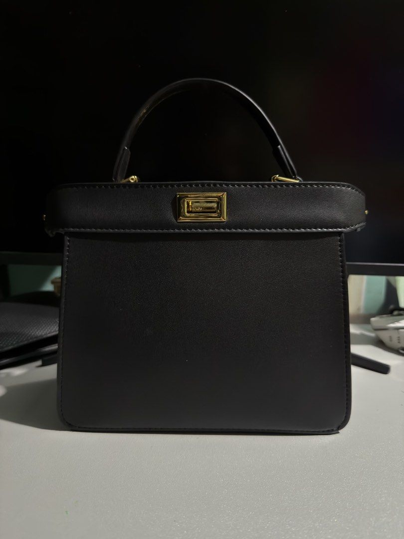 Fendi Peekaboo Mini Black Bag (Category: Luxury Bags & Wallets) located in Cabuyao City. Submitted by gerlieluxurycloset2024 (Listing ID 1428009662, Image 2). Description: Black Fendi handbag with a top handle and a detachable shoulder strap. Features a gold-tone clasp with the Fendi logo. Includes a dust bag and a small card. The interior is black..