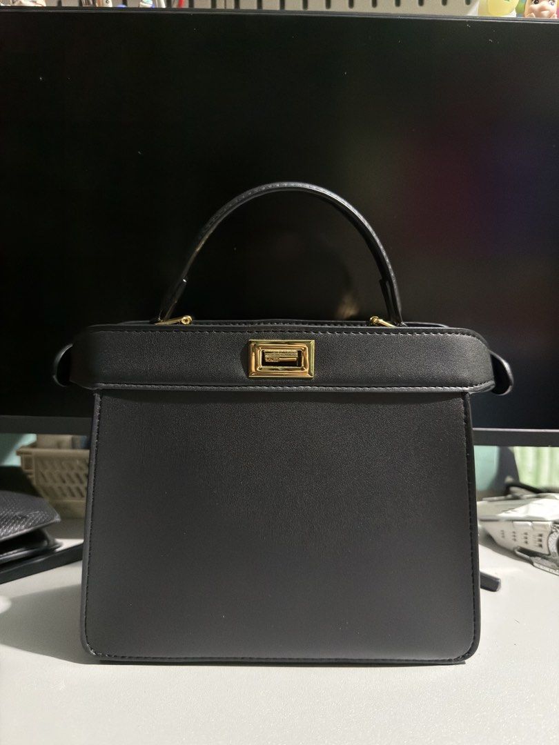Fendi Peekaboo Mini Black Bag (Category: Luxury Bags & Wallets) located in Cabuyao City. Submitted by gerlieluxurycloset2024 (Listing ID 1428009662, Image 1). Description: Black Fendi handbag with a top handle and a detachable shoulder strap. Features a gold-tone clasp with the Fendi logo. Includes a dust bag and a small card. The interior is black..