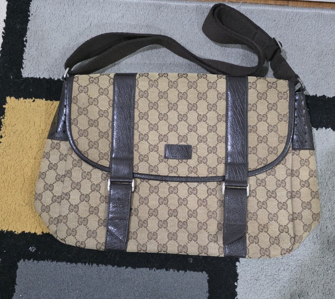 Gucci Canvas Messenger Bag (Category: Luxury Bags & Wallets) located in Makati City. Submitted by PeppermintPanda (Listing ID 1427981903, Image 1). Description: Authentic Gucci messenger bag. Features the iconic GG monogram canvas with leather accents. Includes an adjustable shoulder strap and a flap closure with buckle details. The interior has a brown lining. The bag has a magnetic snap closure. Made in Italy..