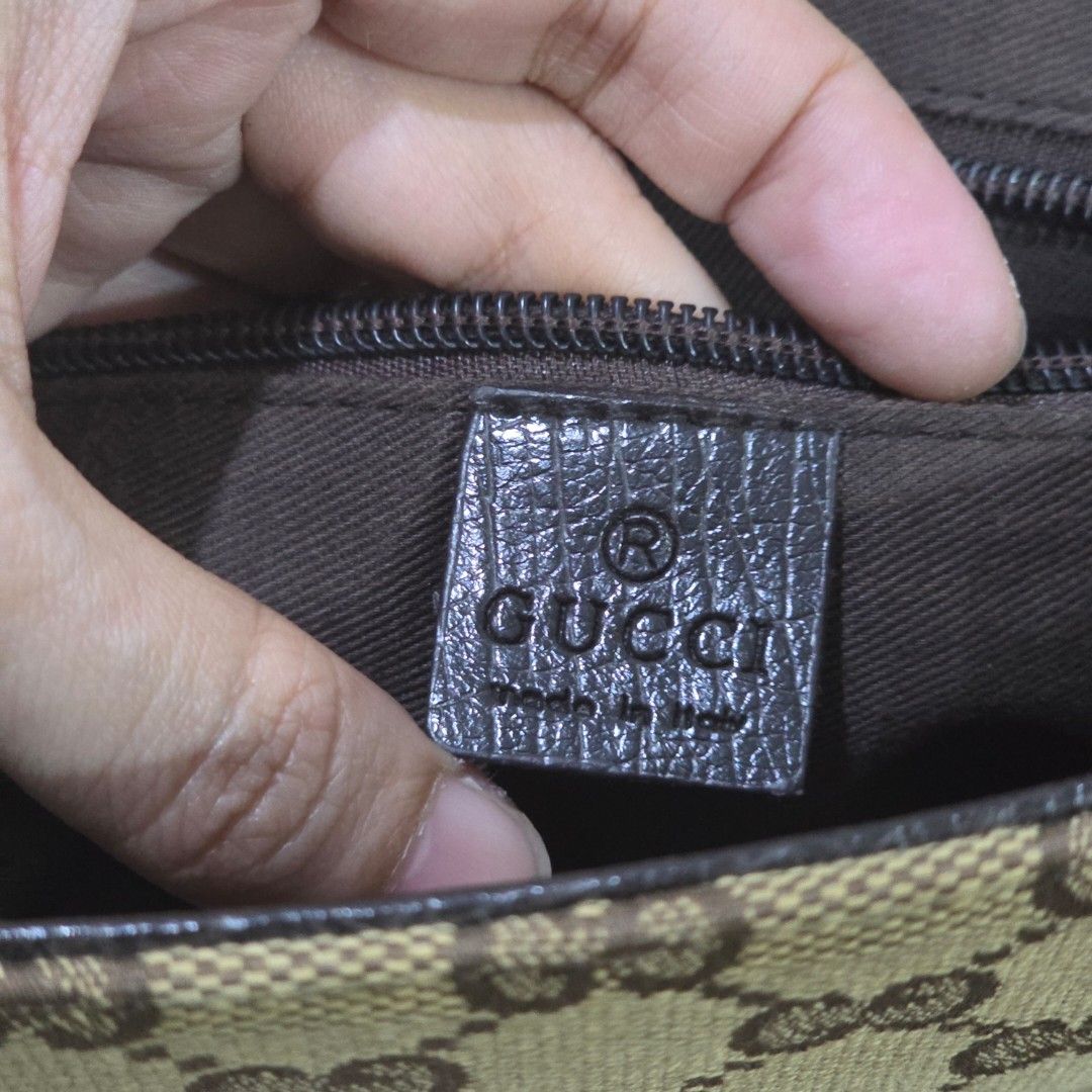 Gucci Canvas Messenger Bag (Category: Luxury Bags & Wallets) located in Makati City. Submitted by PeppermintPanda (Listing ID 1427981903, Image 2). Description: Authentic Gucci messenger bag. Features the iconic GG monogram canvas with leather accents. Includes an adjustable shoulder strap and a flap closure with buckle details. The interior has a brown lining. The bag has a magnetic snap closure. Made in Italy..