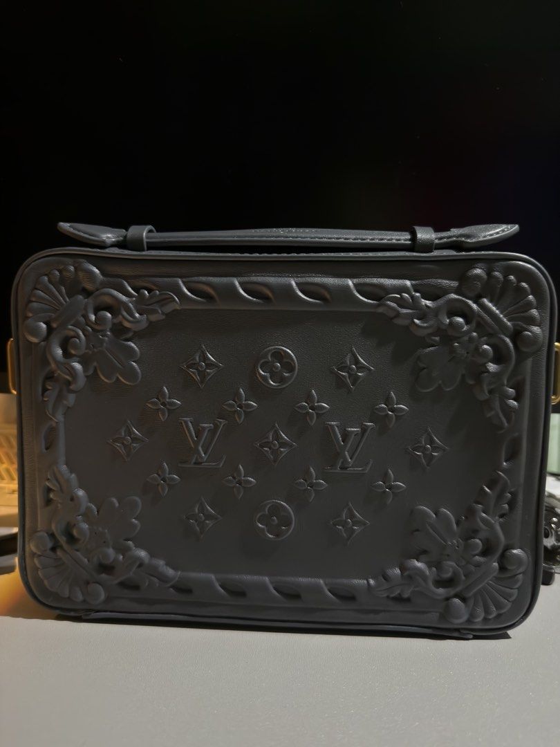 Louis Vuitton Grey Embossed Bag (Category: Luxury Bags & Wallets) located in Cabuyao City. Submitted by gerlieluxurycloset2024 (Listing ID 1428009482, Image 2). Description: Louis Vuitton bag features an embossed design with the LV logo. It has a zip closure and includes a detachable strap. The interior has multiple compartments and a label that reads "LOUIS VUITTON PARIS made in France Defile Homme Printemps-Ete 2023". The bag also has a gold-to