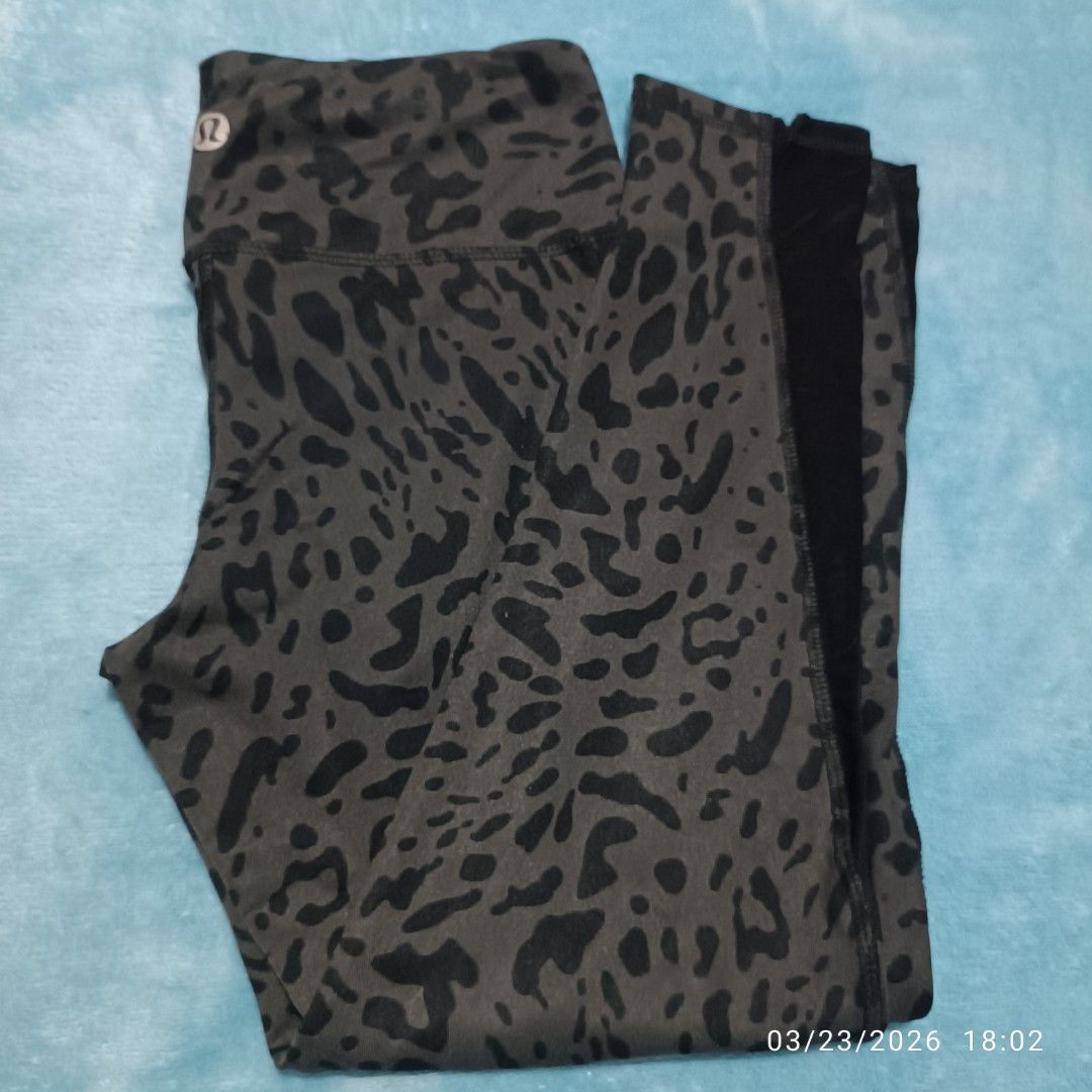 Lululemon Leopard Print Leggings (Category: Activewear) located in Bacoor. Submitted by pamelott (Listing ID 1428021262, Image 3). Description: ​Brand: Lululemon Athletica (indicated by the signature stylized "Ω" logo on the waistband and the inner tag). ​Item Type: High-waisted athletic leggings, likely a 7/8 or crop length. ​Pattern/Color: A dark grey and black "Leopard" or "Cheetah" animal print. The base fabric is a charcoal grey with irregul