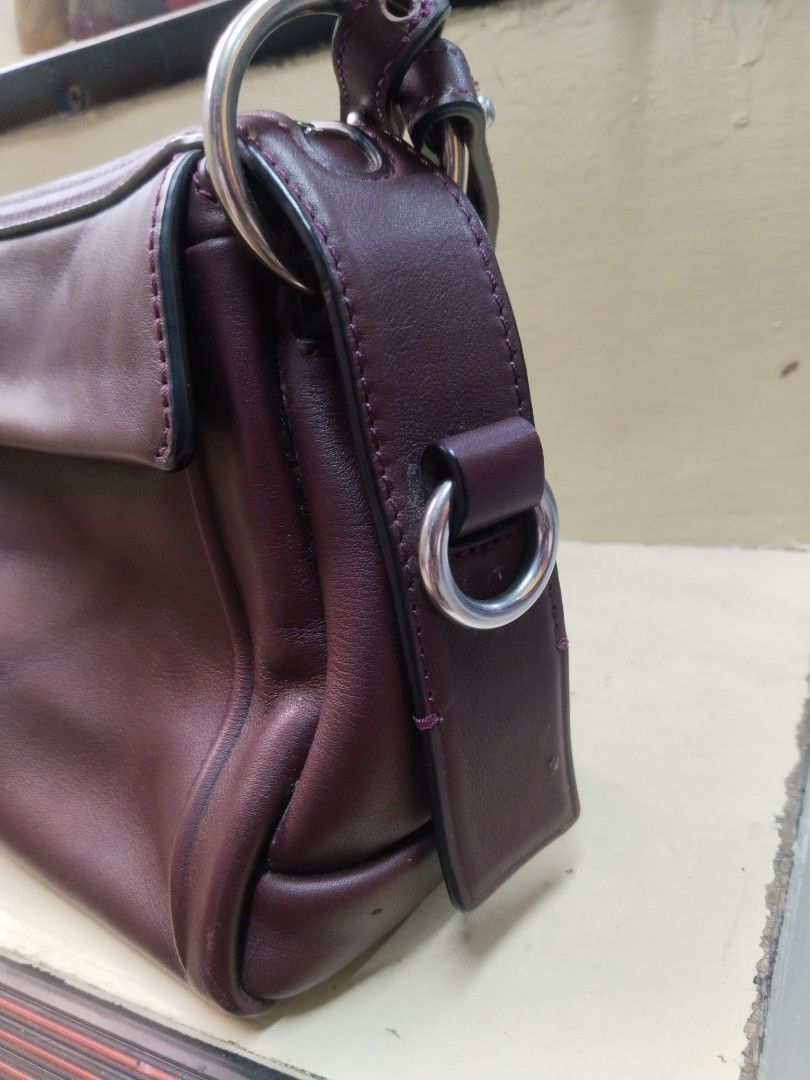 Marc by Marc Jacobs Shoulder Bag/sling 2way (Category: Luxury Bags & Wallets) located in Baguio. Submitted by bangtowanv91137 (Listing ID 1427979626, Image 2). Description: Maroon shoulder bag by Marc by Marc Jacobs. Features a flap closure and a detachable shoulder strap. The bag has silver-tone hardware, including rings and a zipper. A metal tag with the brand name is visible. Includes a detachable strap..