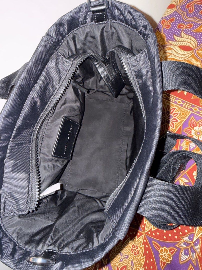 Marc Jacobs Traveler Tote Bag (Category: Luxury Bags & Wallets) located in Quezon City. Submitted by msaisa (Listing ID 1427938855, Image 3). Description: Black Marc Jacobs Traveler Tote Bag. Features a top handle and a detachable shoulder strap. The bag has the Marc Jacobs logo on the straps. The interior has a zip pocket and a small leather tag with the brand name. Includes silver hardware..