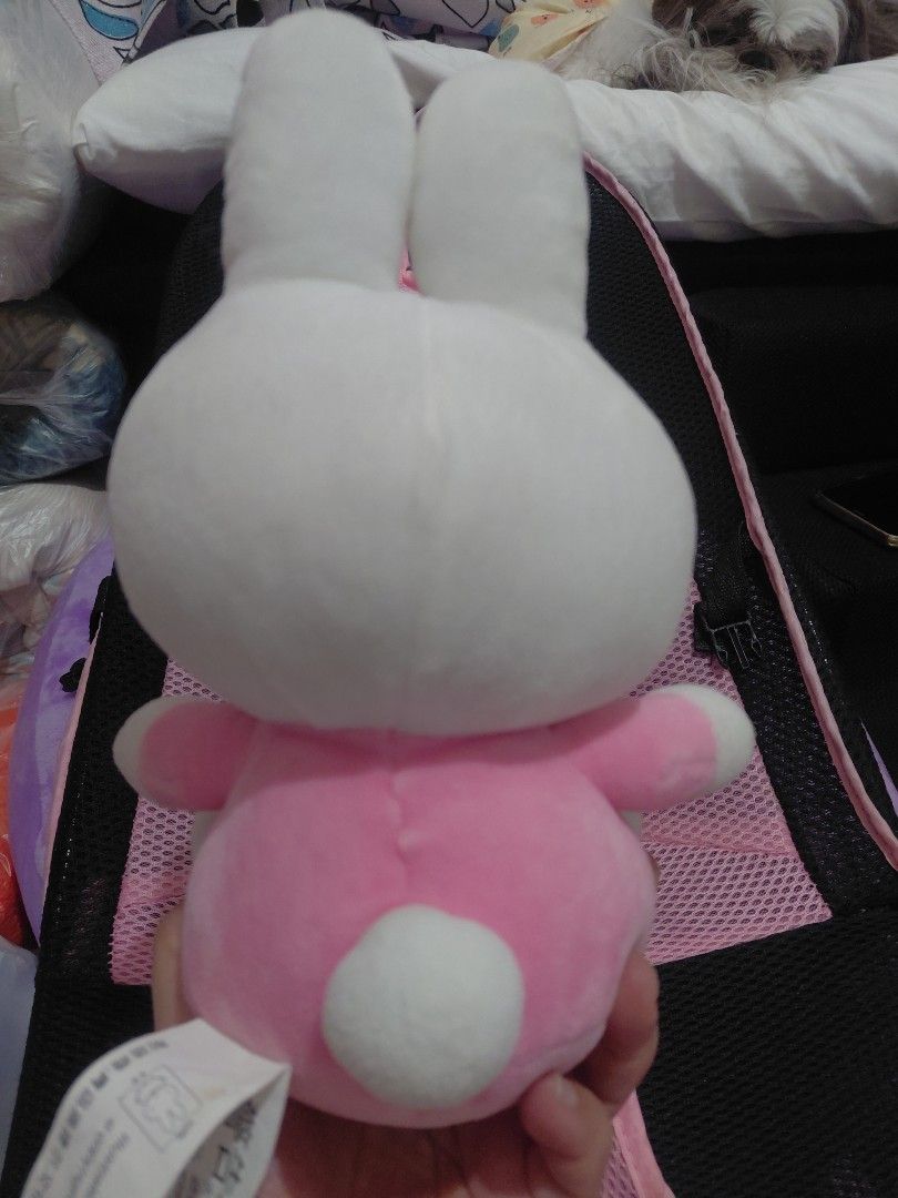 Miffy in Pink Plush Toy (Category: Plushies & Soft Toys) located in Manila. Submitted by bashamylove0116 (Listing ID 1427998185, Image 2). Description: Adorable Miffy Pink plush toy. Features a white bunny head with blue eyes and a pink body with a bow. The toy is soft and cuddly, perfect for kids or collectors. The tag indicates it's an official Miffy product. A cute and charming addition to any collection..