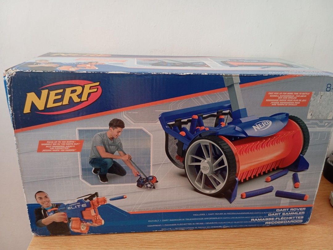 Nerf Dart Rover Dart Sammler (Category: Action & Battle Toys) located in Manila. Submitted by brion123 (Listing ID 1427948501, Image 1). Description: Nerf Dart Rover is designed to pick up darts. It features non-slip wheels and a mesh bag for easy dart retrieval. The box shows the toy and its features. It is suitable for ages 8+. The box also includes a Nerf Elite blaster. brand new never used mejo nqlum lang Yung box .