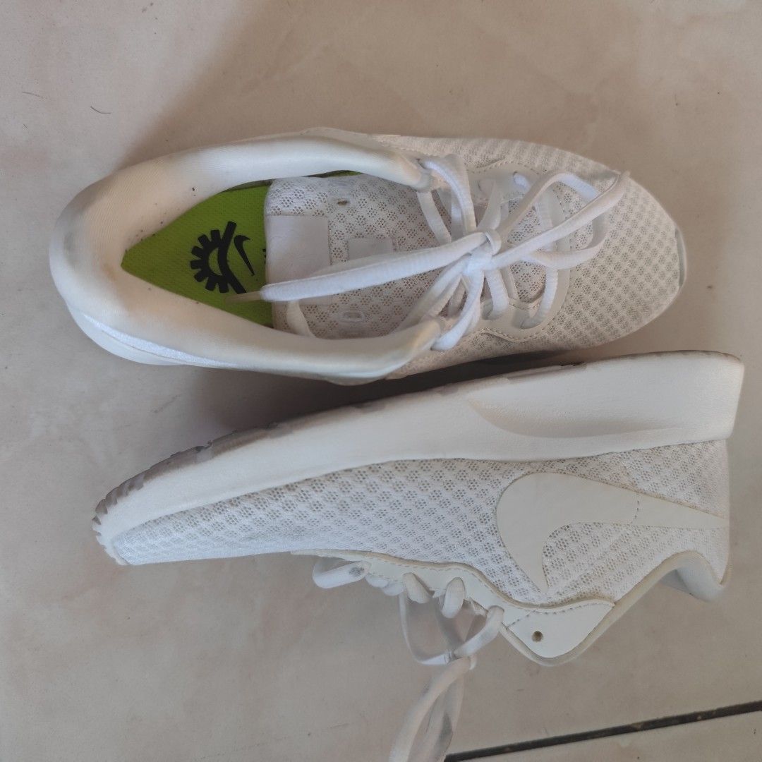 Nike Tanjun White Sneakers (Category: Sneakers) located in Bulacan. Submitted by gentlestorm_408dc4 (Listing ID 1427945541, Image 3). Description: White Nike Tanju sneakers. Features a mesh upper and a white sole. The Nike swoosh logo is visible on the side. The insole is green with a Nike logo. The laces are white. Original from US 9 inches long, size 5 My aunt gave it to me Im size 6 but I am now size 7 after giving birth.