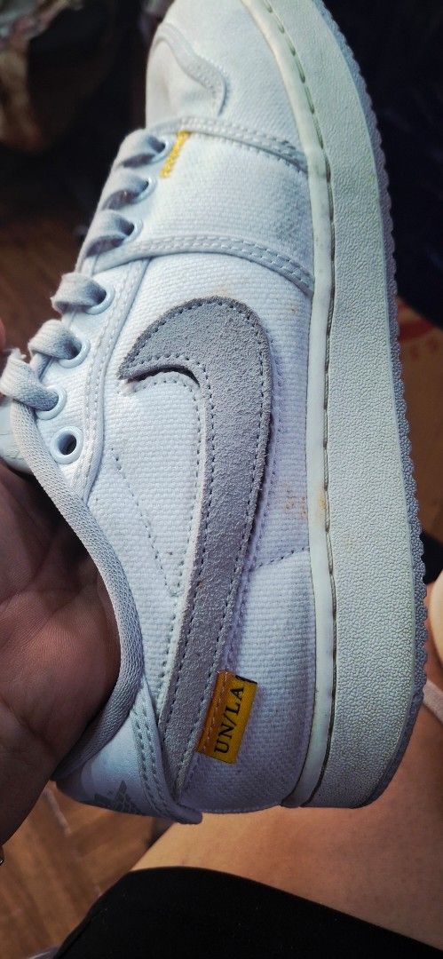 Nike x UN/LA Jordan 1 Low (Category: Sneakers) located in Manila. Submitted by bee.geema (Listing ID 1428003145, Image 3). Description: These Nike x UN/LA Jordan 1 Low sneakers feature a light blue and grey colorway. The shoes have the Nike swoosh logo and the UN/LA tag. The size is 7.5. The soles show some wear. The shoes have white laces and a white sole..
