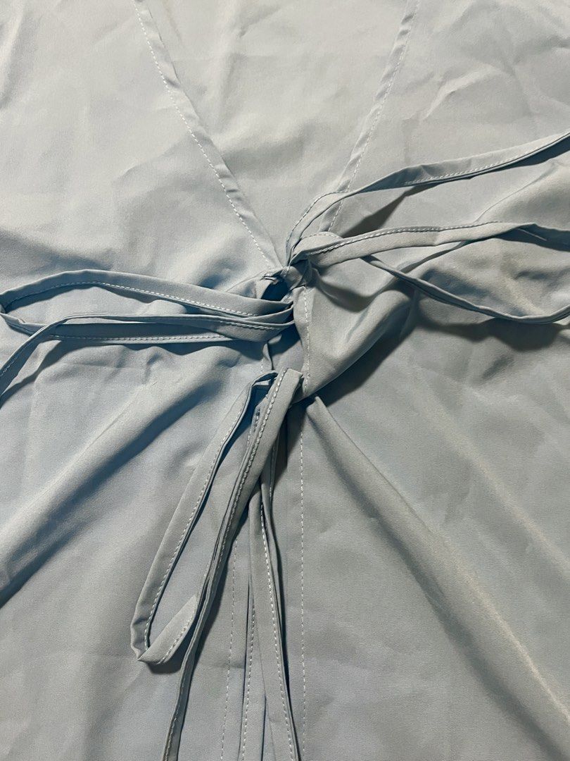 Tie-Front Long Sleeve Top (Category: Blouses) located in Makati City. Submitted by sixelaa (Listing ID 1428027530, Image 2). Description: Long-sleeved top features a flattering tie-front design. It has a V-neckline and is made of a smooth, light blue fabric. It's a versatile piece that can be dressed up or down. Fits XS-S.
