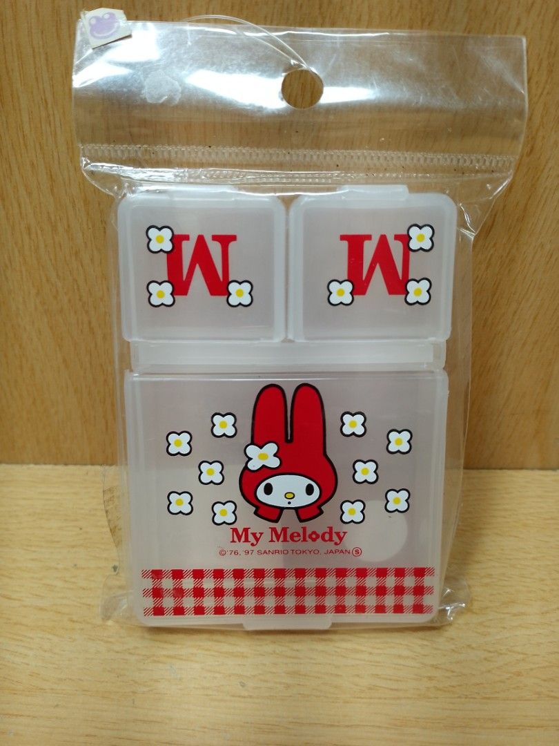 1990's My Melody 3-Compartment mini Storage Box (Category: Storage Boxes & Baskets) located in Davao. Submitted by washerjeni08452 (Listing ID 1428223170, Image 1). Description: My Melody storage box features a 3-compartment design. The top section has two compartments with the letter "M" on the lids. The bottom section showcases My Melody with a red and white checkered pattern. It is a Sanrio product, made in Japan. For San Rio collectors mint c