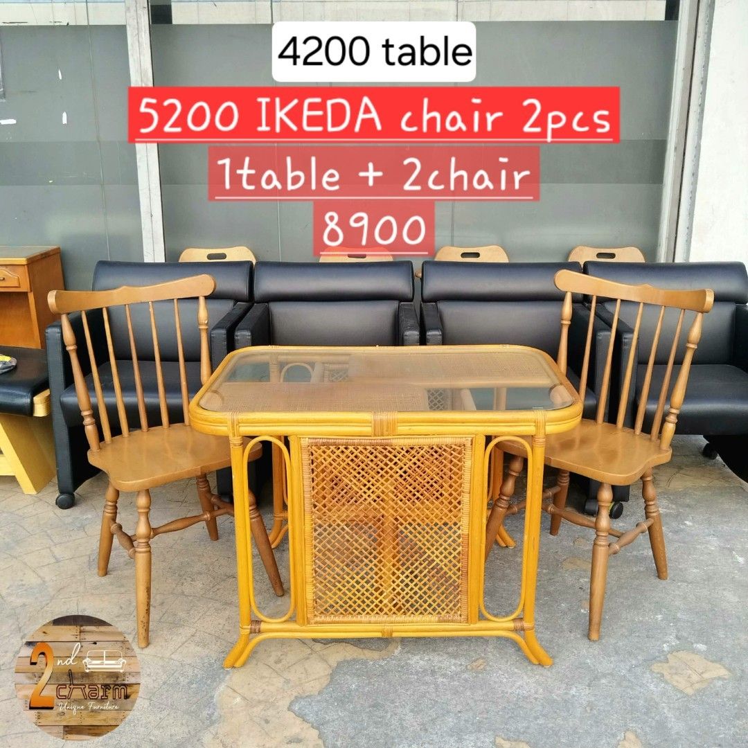 2nd hand Natural Rattan Table with 2 Windsor Chairs (Category: Tables & Sets) located in Paranaque City. Submitted by feybelhaft (Listing ID 1428206797, Image 2). Description: Set includes a rattan table with a glass top and two wooden chairs. The table dimensions are L90 W60 H66cm. The chairs are labeled as IKEDA. The table has a unique woven design on the front. The chairs have a classic spindle back design. The table is sold separately for 420