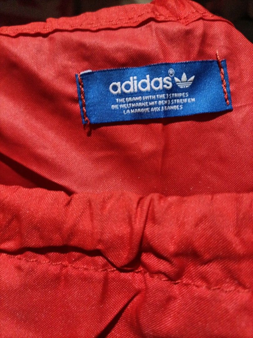 Adidas Originals Drawstring Bag (Category: Backpacks) located in Bocaue. Submitted by michellesell_2 (Listing ID 1428228822, Image 2). Description: Red drawstring bag featuring the Adidas Originals logo. The bag has a large white circular design with the word "ORIGINALS" and a large "A" in the center. The Adidas trefoil logo is visible below the "A"..