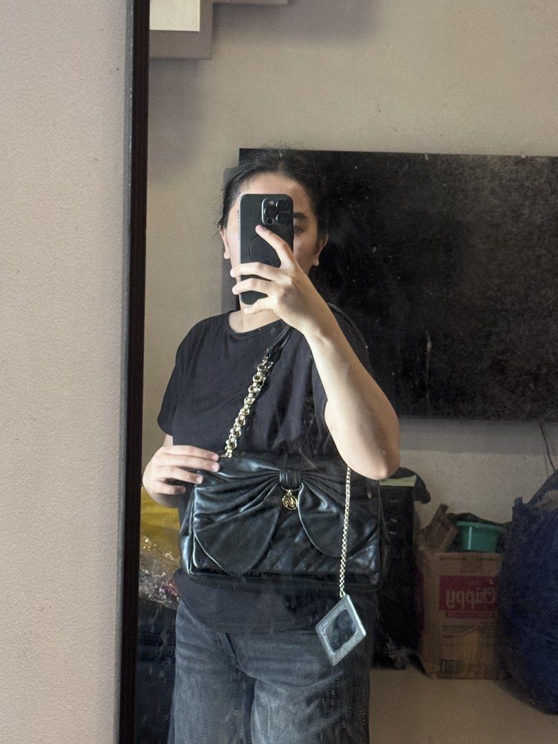 Authentic Nina Ricci Black Bow Shoulder Bag (Category: Luxury Bags & Wallets) located in Manila. Submitted by thriftyhaven2023 (Listing ID 1428105853, Image 2). Description: - Authentic Nina Ricci shoulder bag - Features a unique bow design - Classic black color - Gold chain strap - Perfect for everyday use or special occasions 9/10 condition Pristine condition .
