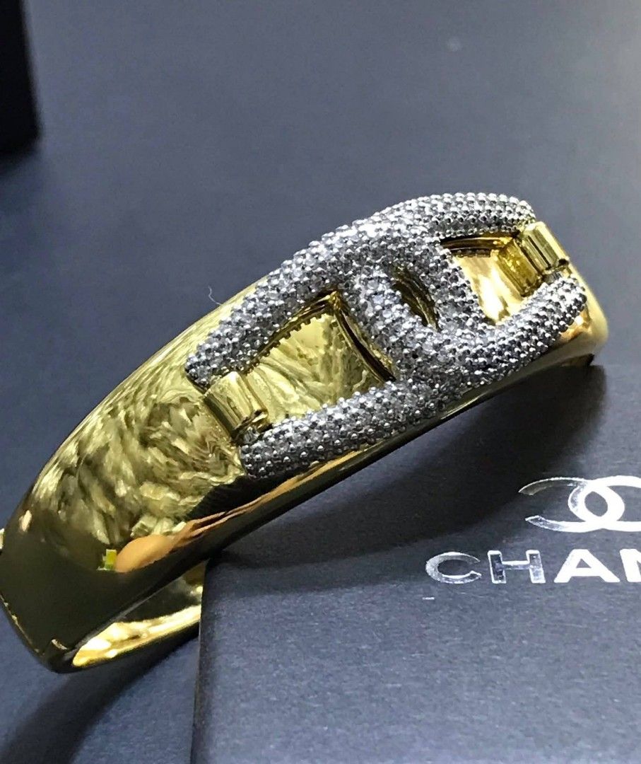 Chanel Gold Bracelet with Crystals (Category: Luxury Accessories) located in Manila. Submitted by celstainlessjewelry (Listing ID 1428186024, Image 1). Description: Elegant gold bracelet featuring a prominent Chanel logo embellished with sparkling crystals. The bracelet has a polished, reflective surface. The bracelet is presented in a black box, suggesting it is a luxury item..