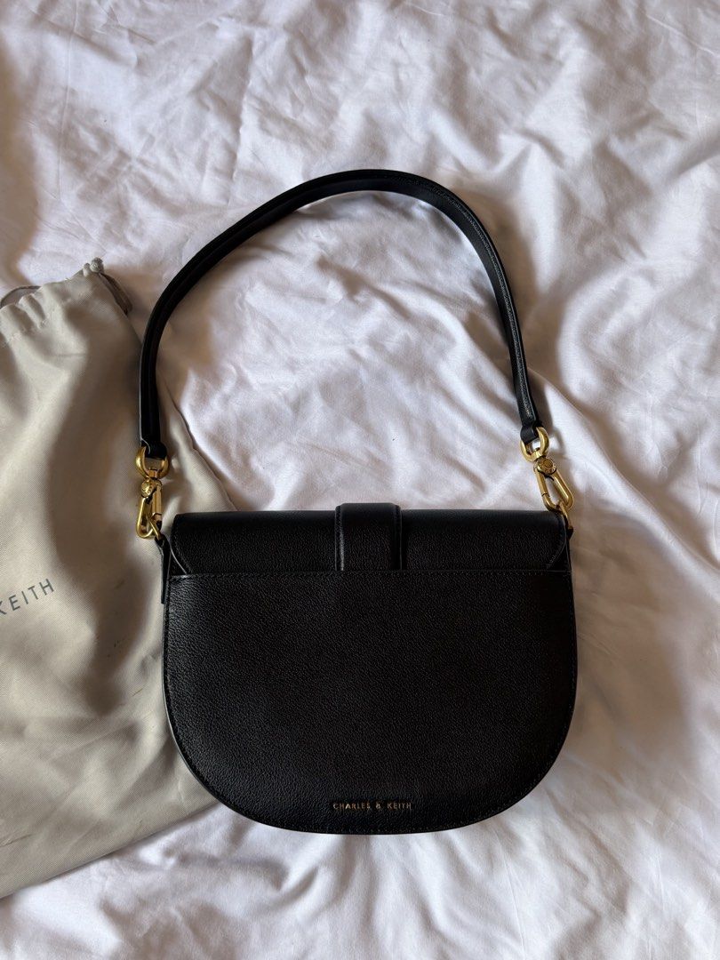 Charles & Keith Gabine Black Saddle Bag (Category: Cross-body Bags) located in Mandaluyong City. Submitted by ldr.aa (Listing ID 1428124958, Image 3). Description: Condition: 9/10 - Had it engraved with my initials (see photos) - It has white powder marks inside from when I left my powder open. I think its removable naman..