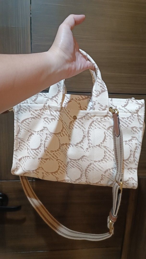 Coach New York Canvas Handbag (Category: Luxury Bags & Wallets) located in Cavite. Submitted by premfinds (Listing ID 1428252474, Image 2). Description: Coach New York handbag with a canvas exterior. Features a top handle and a detachable shoulder strap. The bag has a brown leather tag and gold-tone hardware. The interior has a fabric lining. Made in Cambodia. Orig. Almost new condition..