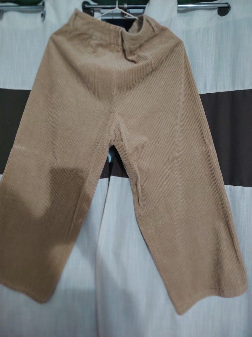 GU Corduroy Wide Leg Pants (Category: Other Bottoms) located in Quezon City. Submitted by nenggie (Listing ID 1428123255, Image 1). Description: Tan corduroy wide leg pants from GU. Features a button and zipper closure. The pants have a relaxed fit and a wide leg opening. The size tag is visible in the image. Fits waistline 26 to 28.