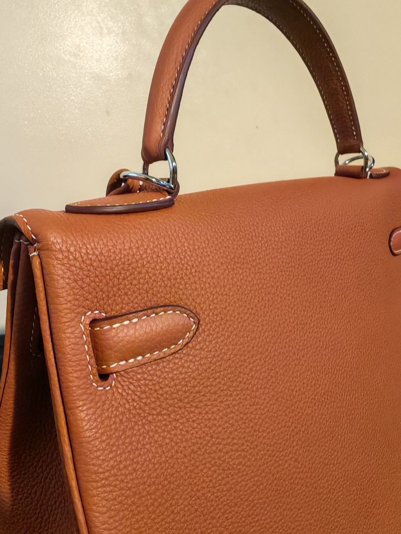 Hermes Kelly Handbag 32 (Category: Luxury Bags & Wallets) located in Manila. Submitted by shoppingspree008 (Listing ID 1428120047, Image 2). Description: Beautiful Hermès Kelly handbag in a rich tan color. Features a top handle, a secure clasp closure, and a leather strap, clochete with a key and padlock. The bag showcases the Hermès Paris stamp and code..