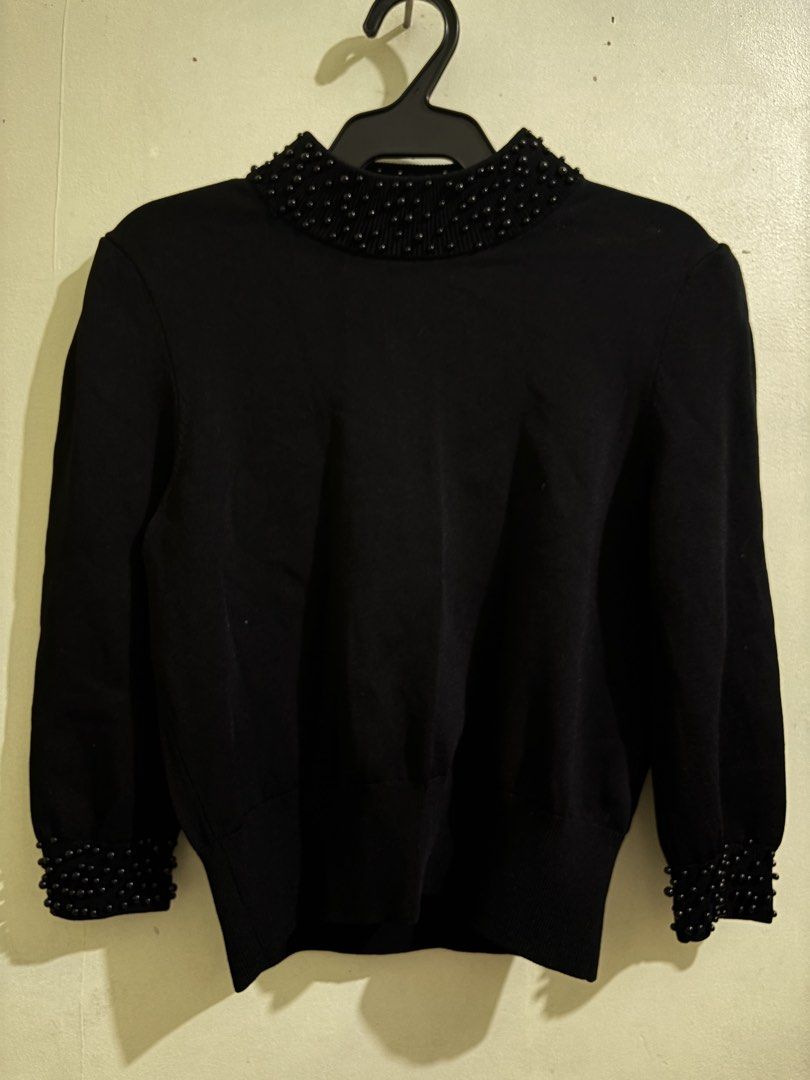 H&M Black Sweater with Bead Embellishments (Category: Longsleeves) located in Marikina City. Submitted by zspreloved_ (Listing ID 1428190330, Image 1). Description: Elegant black sweater from H&M. Features a high neckline and cuffs adorned with small, dark beads. The sweater has long sleeves and a classic, fitted silhouette. The tag indicates an XS size. Perfect for adding a touch of sophistication to any outfit..