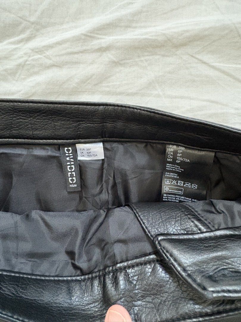 H&M Divided Black Leather Skirt (Category: Skirts) located in Cebu City. Submitted by declutterwithmecebu (Listing ID 1428142386, Image 2). Description: Black faux leather skirt from H&M Divided. Features a diagonal zipper and a small pocket. The skirt has a size 38P, which is equivalent to a US size 6 and a CN size 155/72A. The waist measures approximately 14 inches across. The length of the skirt is approximately 17 inches..