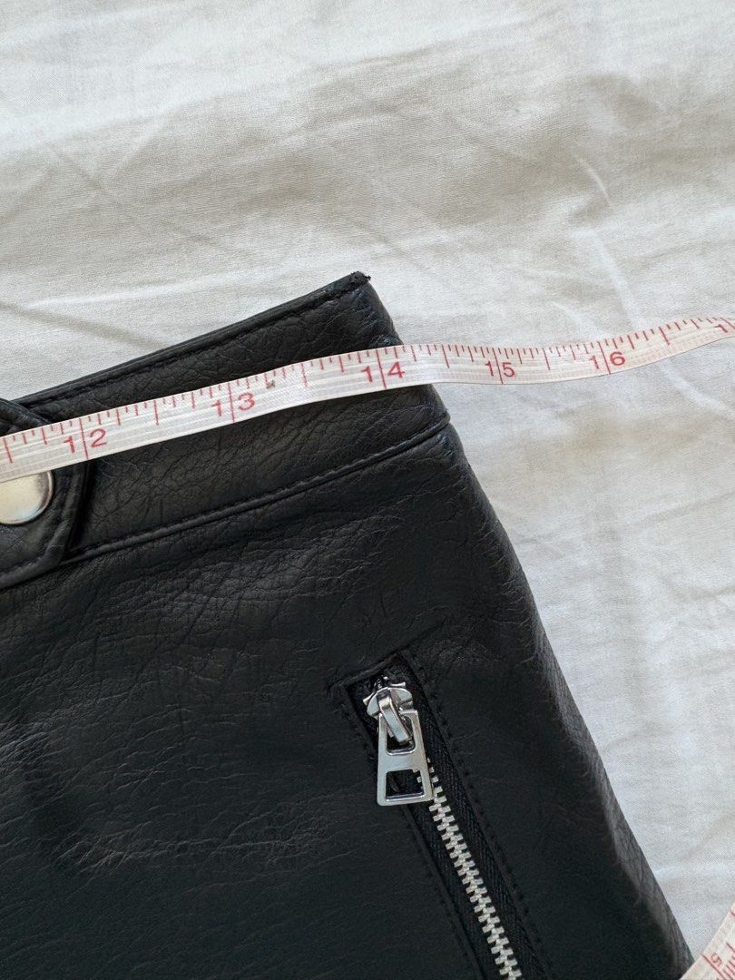 H&M Divided Black Leather Skirt (Category: Skirts) located in Cebu City. Submitted by declutterwithmecebu (Listing ID 1428142386, Image 3). Description: Black faux leather skirt from H&M Divided. Features a diagonal zipper and a small pocket. The skirt has a size 38P, which is equivalent to a US size 6 and a CN size 155/72A. The waist measures approximately 14 inches across. The length of the skirt is approximately 17 inches..