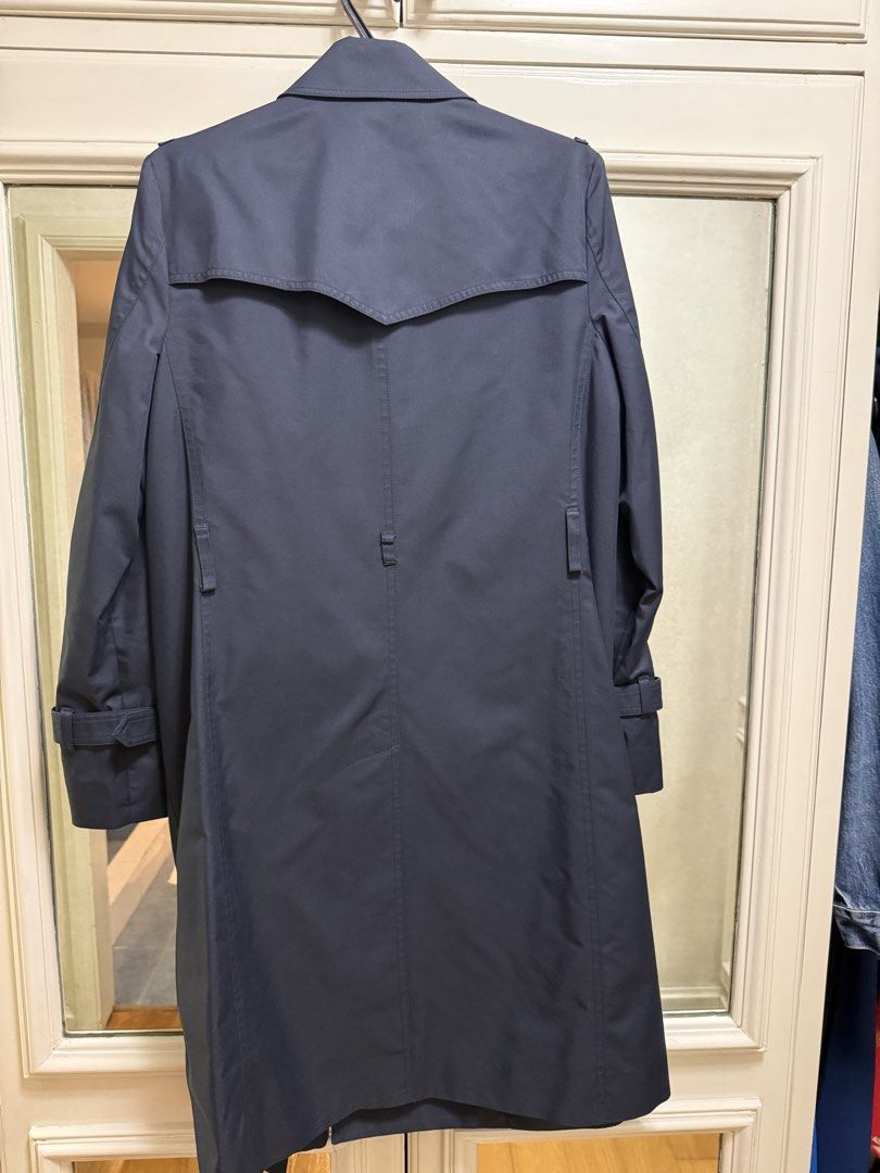 Navy Trench Coat - Size M (Category: Coats, Jackets and Outerwear) located in Quezon City. Submitted by declutter1ngmama (Listing ID 1428239429, Image 3). Description: Classic navy trench coat. Features a double-breasted design with button closures and adjustable cuffs. The coat has a tailored fit and a back vent for ease of movement. Comes with belt Used only once Size M..