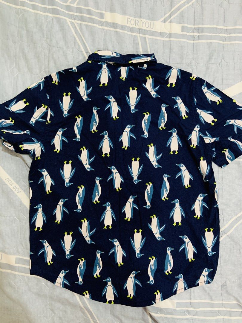 Old Navy Penguin Print Shirt (Category: Babies & Kids Fashion) located in Rizal. Submitted by itsmecarebear (Listing ID 1428135188, Image 3). Description: Old Navy shirt features a fun penguin print. It has short sleeves and a button-down design. The shirt is size S (6-7) and made in Bangladesh. The shirt is navy blue with a pattern of white and blue penguins..