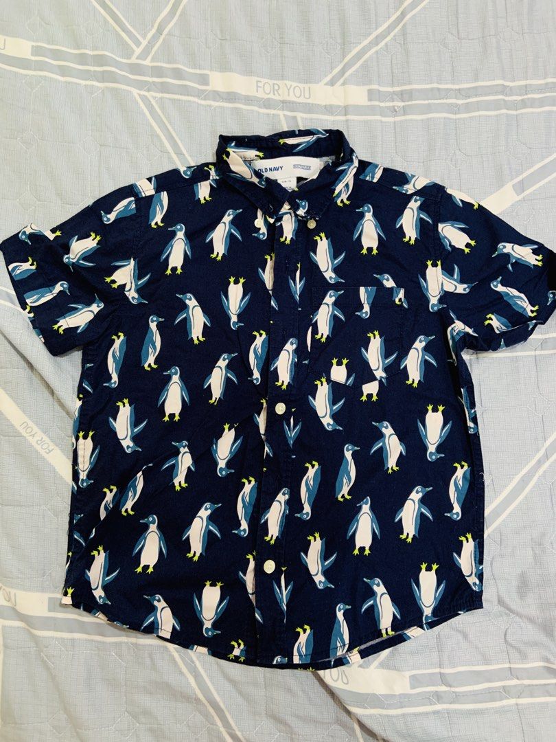 Old Navy Penguin Print Shirt (Category: Babies & Kids Fashion) located in Rizal. Submitted by itsmecarebear (Listing ID 1428135188, Image 1). Description: Old Navy shirt features a fun penguin print. It has short sleeves and a button-down design. The shirt is size S (6-7) and made in Bangladesh. The shirt is navy blue with a pattern of white and blue penguins..