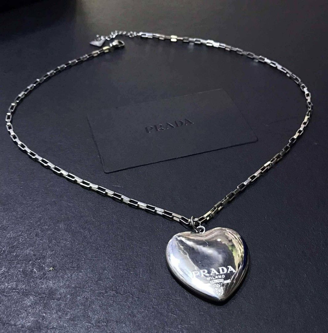 Prada Heart Pendant Necklace (Category: Luxury Accessories) located in Manila. Submitted by celstainlessjewelry (Listing ID 1428186614, Image 2). Description: Elegant Prada heart pendant necklace. Available in gold and silver tones. Features a heart-shaped pendant with the Prada logo. The necklace has a chain design. Comes with a Prada box and ribbon..