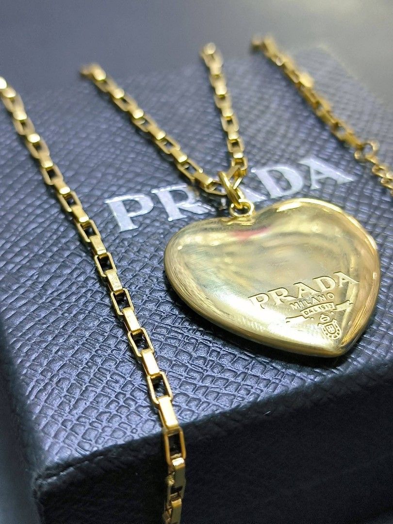 Prada Heart Pendant Necklace (Category: Luxury Accessories) located in Manila. Submitted by celstainlessjewelry (Listing ID 1428186614, Image 3). Description: Elegant Prada heart pendant necklace. Available in gold and silver tones. Features a heart-shaped pendant with the Prada logo. The necklace has a chain design. Comes with a Prada box and ribbon..