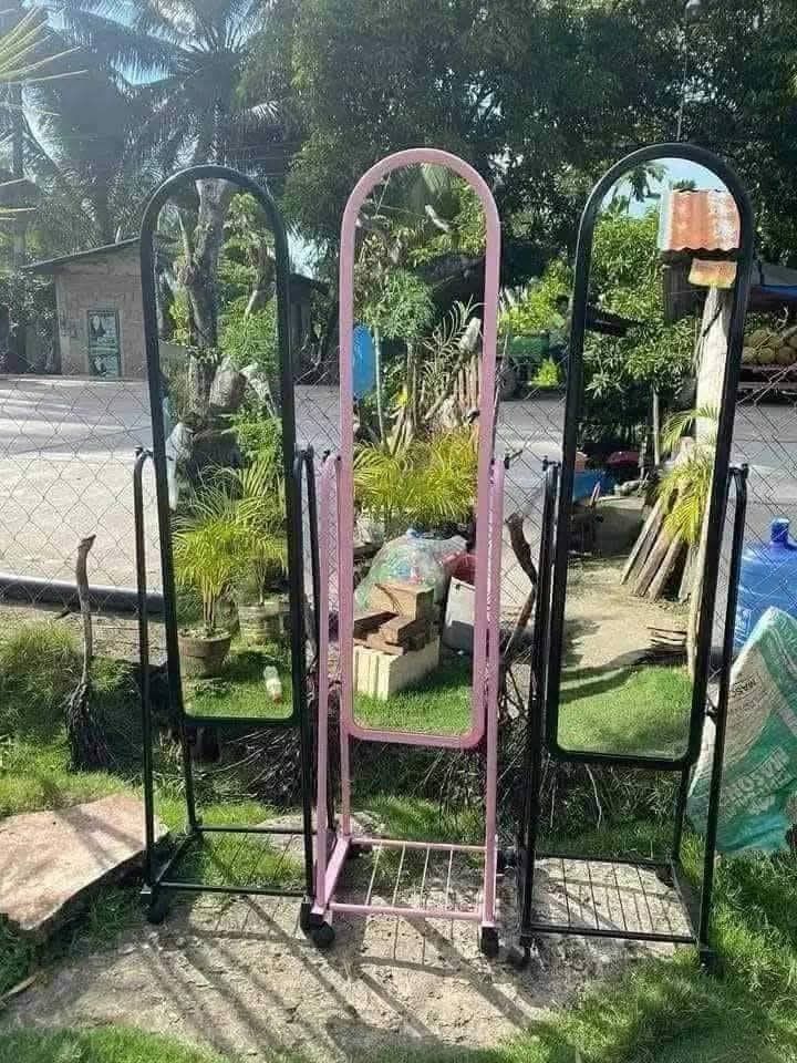 Standing Full Body Mirror with Rack (Category: Mirrors) located in Quezon City. Submitted by diannecaya86853 (Listing ID 1428253794, Image 2). Description: Full-length standing mirror with a metal frame and a built-in rack. Available in black and white frame colors. The mirror has a curved top design and is mounted on a wheeled base for easy movement. Suitable for bedrooms, dressing rooms, or any space needing a full-body mirror..