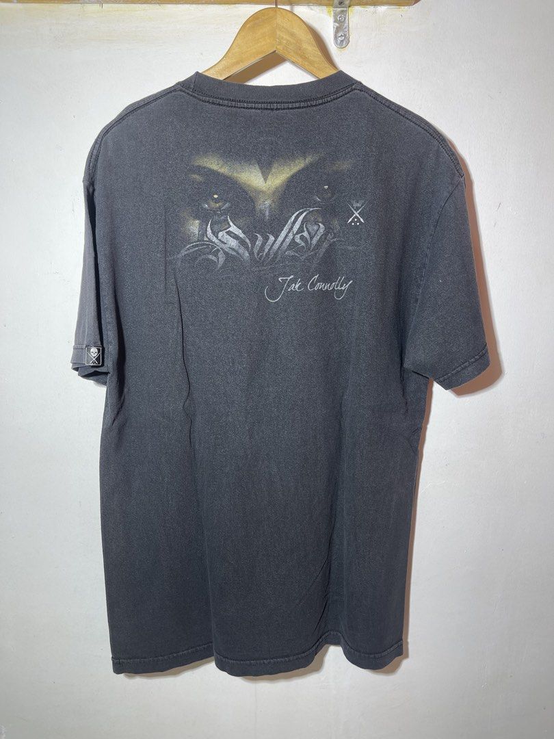 Swollen Art Collective Graphic Tee y2k (Category: Tshirts & Polo Shirts ) located in Bulacan. Submitted by archivesgallery_ (Listing ID 1428165430, Image 2). Description: Size large 22 pit to pit 30 neck to hem Minor fading Graphic tee features a striking face design on the front and back, with the words "Jak Connolly" printed on the back. It is a large size and made by Swollen Art Collective. The shirt has a crew neck and short sleeves. The shir