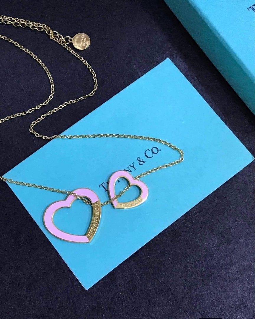 Tiffany & Co. Double Heart Necklace (Category: Luxury Accessories) located in Manila. Submitted by celstainlessjewelry (Listing ID 1428185928, Image 3). Description: Tiffany & Co. necklace features a double heart pendant design. The necklace comes with a box, a pouch, and a card. The hearts are available in various colors, including pink and turquoise, with the Tiffany & Co. logo visible on the pendant..