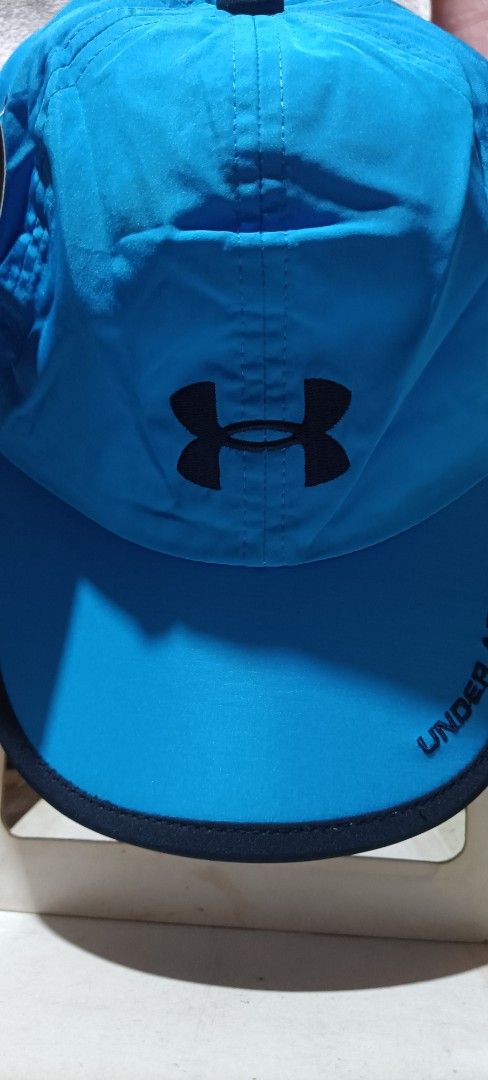 Under Armour Running Cap (Category: Caps & Hats) located in Bocaue. Submitted by michellesell_2 (Listing ID 1428237149, Image 1). Description: Under Armour running cap is a vibrant blue. It features the Under Armour logo prominently displayed on the front. The cap has a curved brim and a dark blue trim. Authenticity not sure. with tag few washable yellow stain. .
