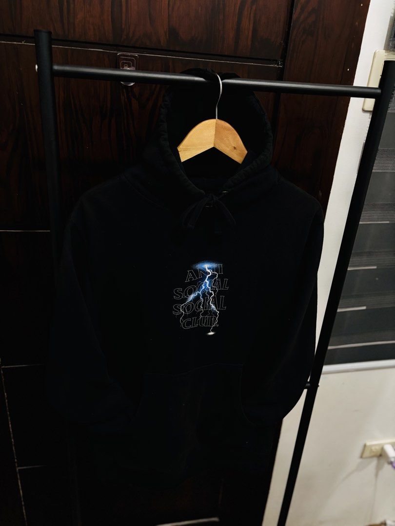 Anti Social Social Club Lightning Hoodie (Category: Hoodies) located in Binan City. Submitted by worldofthrift1001 (Listing ID 1428405166, Image 1). Description: Black hoodie featuring the Anti Social Social Club logo with a lightning bolt design on the front and back. It has a hood with drawstrings and a kangaroo pocket. The hoodie is displayed on a hanger..