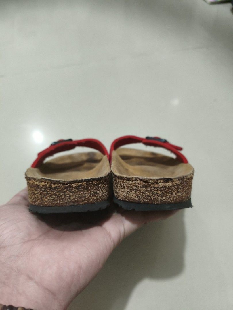 Birkenstock Madrid Red Sandals (Category: Flats & Sandals) located in Manila. Submitted by randomitemsss (Listing ID 1428369730, Image 2). Description: These Birkenstock sandals feature a red strap with a buckle closure. The footbed is made of cork. The soles are black with a wavy pattern. The brand name is visible on the strap. These sandals are perfect for casual wear..