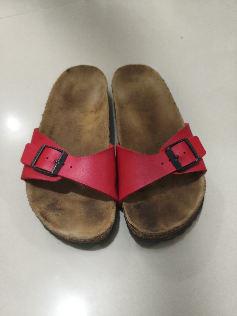 Birkenstock Madrid Red Sandals (Category: Flats & Sandals) located in Manila. Submitted by randomitemsss (Listing ID 1428369730, Image 1). Description: These Birkenstock sandals feature a red strap with a buckle closure. The footbed is made of cork. The soles are black with a wavy pattern. The brand name is visible on the strap. These sandals are perfect for casual wear..