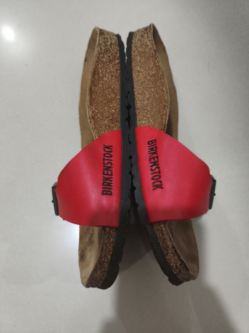 Birkenstock Madrid Red Sandals (Category: Flats & Sandals) located in Manila. Submitted by randomitemsss (Listing ID 1428369730, Image 3). Description: These Birkenstock sandals feature a red strap with a buckle closure. The footbed is made of cork. The soles are black with a wavy pattern. The brand name is visible on the strap. These sandals are perfect for casual wear..