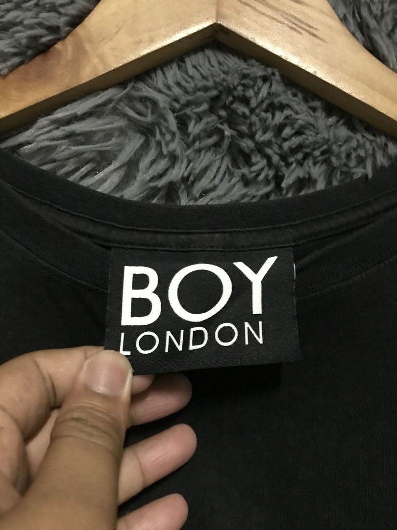 Boy London Black T-shirt (Category: Tshirts & Polo Shirts ) located in Manila. Submitted by thrift_marvs (Listing ID 1428416637, Image 2). Description: Black Boy London T-shirt with a skull and wings design on the back. Features the Boy London logo on the front. The shirt has a crew neck and short sleeves. The tag is visible, confirming the brand. The design on the back includes a skull with wings and a chain..