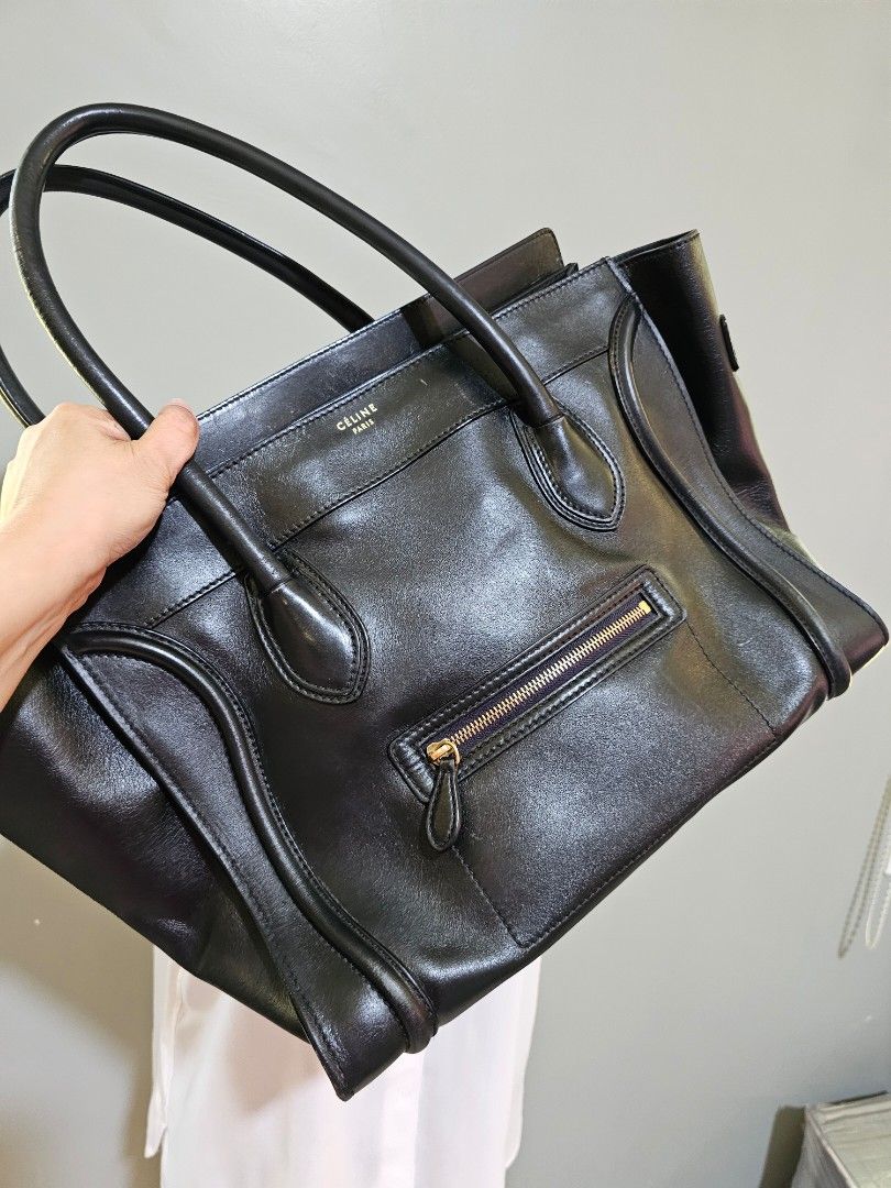 💯AUTH Celine Black Leather Handbag (Category: Luxury Bags & Wallets) located in Cagayan de Oro. Submitted by hotpink26 (Listing ID 1428424424, Image 2). Description: Black leather handbag with gold-toned hardware. Features a top zipper closure and multiple interior compartments. Includes double top handles and a front exterior zipper pocket. The Celine logo is visible on the front of the bag..