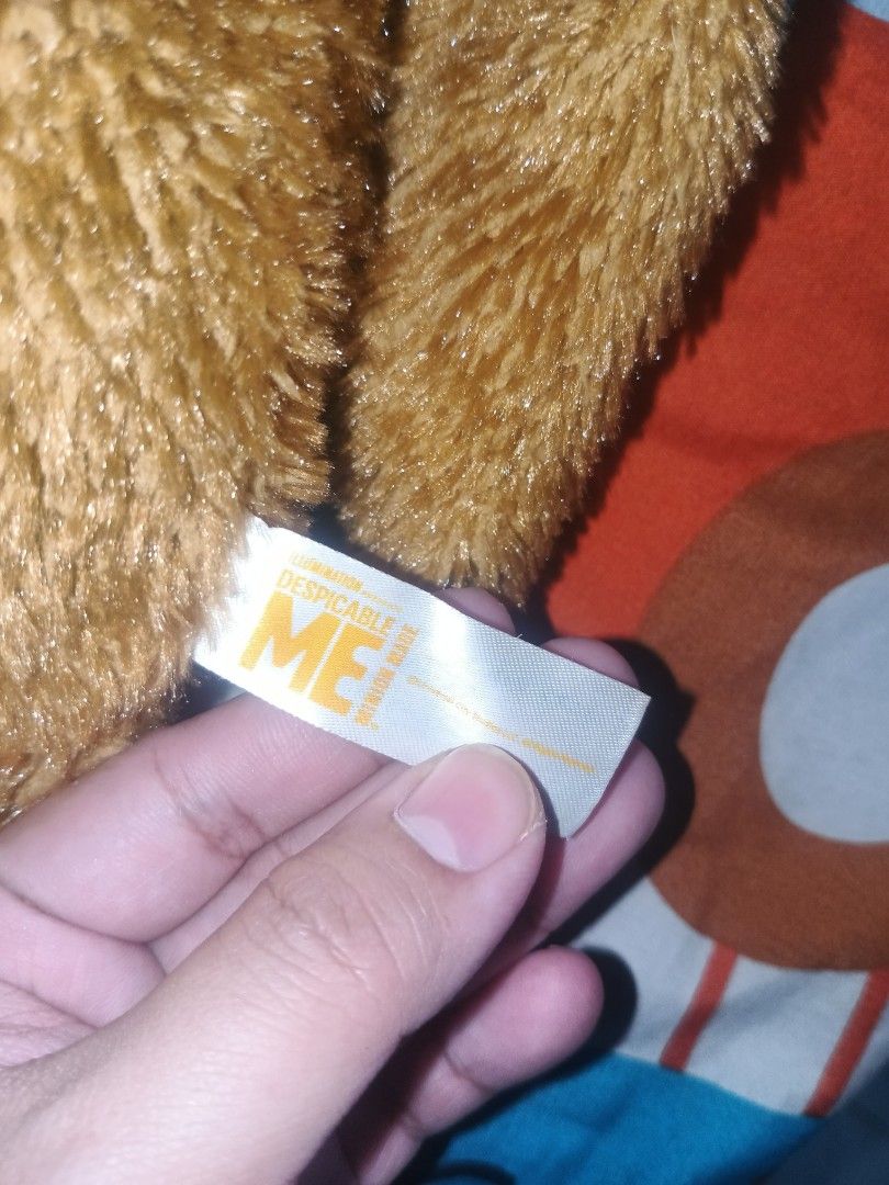 Despicable Me Tim Bear Bob Minion Plush Toy (Category: Plushies & Soft Toys) located in Manila. Submitted by harpercbrr36253 (Listing ID 1428303841, Image 3). Description: Tim plush toy from the Despicable Me franchise. It features a brown fur, button eyes, and a pink tongue. The tag indicates it is a SEGA product. The plush toy has a cute and unique design, perfect for fans of the movie. 19 inches huggable plushie.