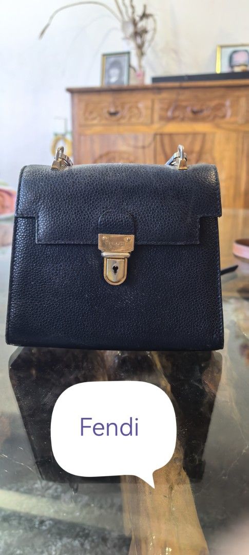 Fendi Black Leather Handbag (Category: Luxury Bags & Wallets) located in Cagayan de Oro. Submitted by tommygurl1218 (Listing ID 1428373040, Image 1). Description: Classic Fendi handbag in black leather. Features a gold-tone clasp closure and a structured design. The leather has a textured appearance. The bag is a timeless piece. Replaced sling. With sign of use.
