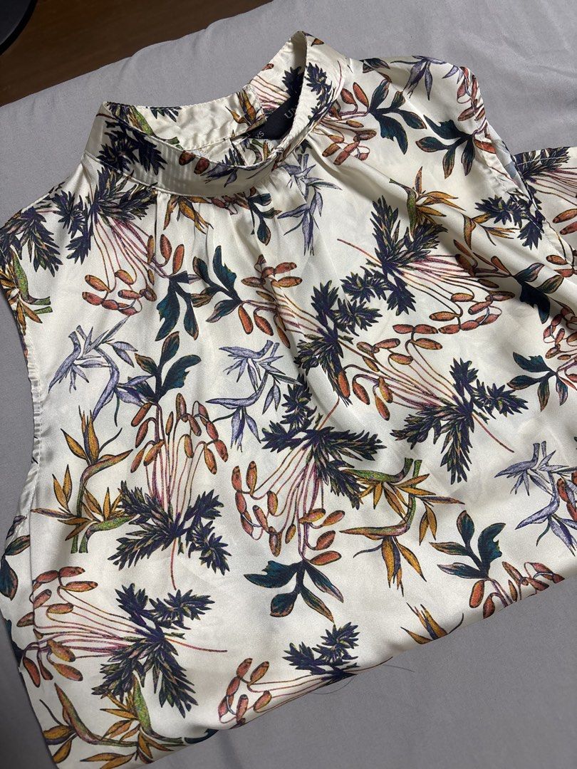 Floral Print Sleeveless Blouse (Category: Blouses) located in Manila. Submitted by mleia (Listing ID 1428352692, Image 1). Description: Sleeveless blouse features a beautiful floral print. It has a high neckline and a relaxed fit. The blouse is a cream color with a colorful floral pattern..