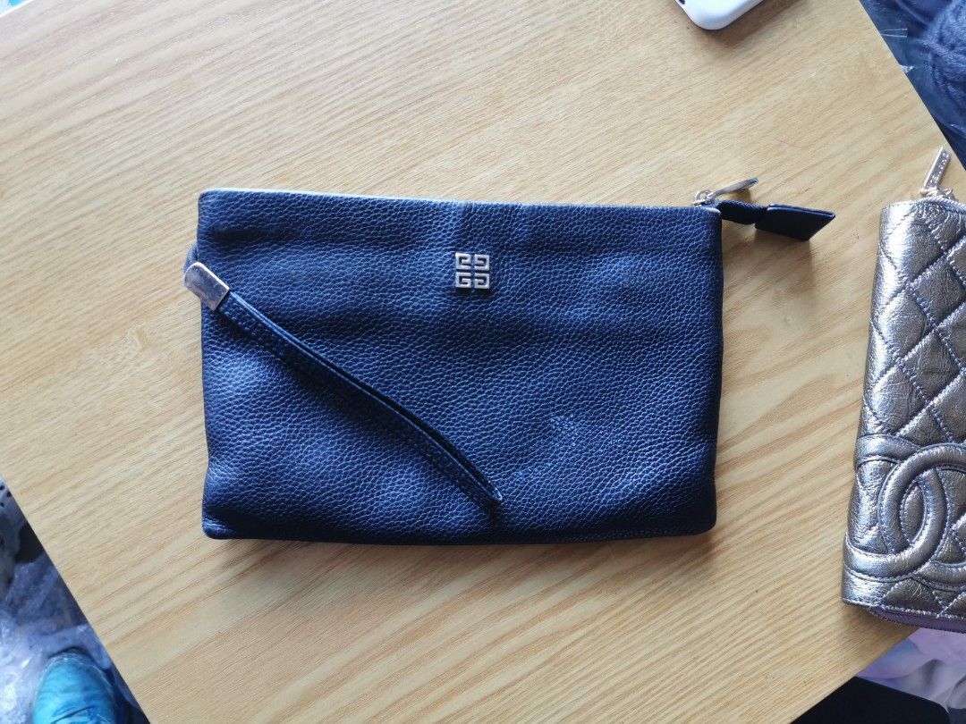 Givenchy Black Leather Clutch (Category: Luxury Bags & Wallets) located in Davao. Submitted by dmp1993 (Listing ID 1428278259, Image 1). Description: Authentic Givenchy clutch in black leather. Features a wrist strap and a zip closure. The interior includes card slots and a Givenchy label. The serial number is visible. The exterior has the Givenchy logo. The clutch is a classic design, perfect for carrying essentials..