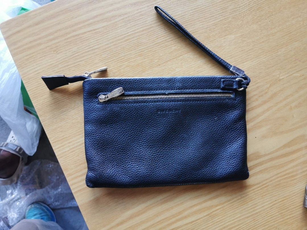 Givenchy Black Leather Clutch (Category: Luxury Bags & Wallets) located in Davao. Submitted by dmp1993 (Listing ID 1428278259, Image 2). Description: Authentic Givenchy clutch in black leather. Features a wrist strap and a zip closure. The interior includes card slots and a Givenchy label. The serial number is visible. The exterior has the Givenchy logo. The clutch is a classic design, perfect for carrying essentials..