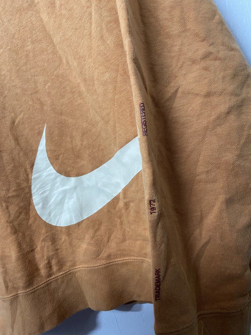 Nike Big Swoosh Sweatshirt XL (Category: Coats, Jackets and Outerwear) located in Quezon City. Submitted by thriftkitaph (Listing ID 1428397238, Image 3). Description: Nike sweatshirt in a burnt orange color with a large white swoosh design. Features the Nike logo on the tag and the word "registered" and "trademark" printed on the sleeve. The size is XL. Made in China..